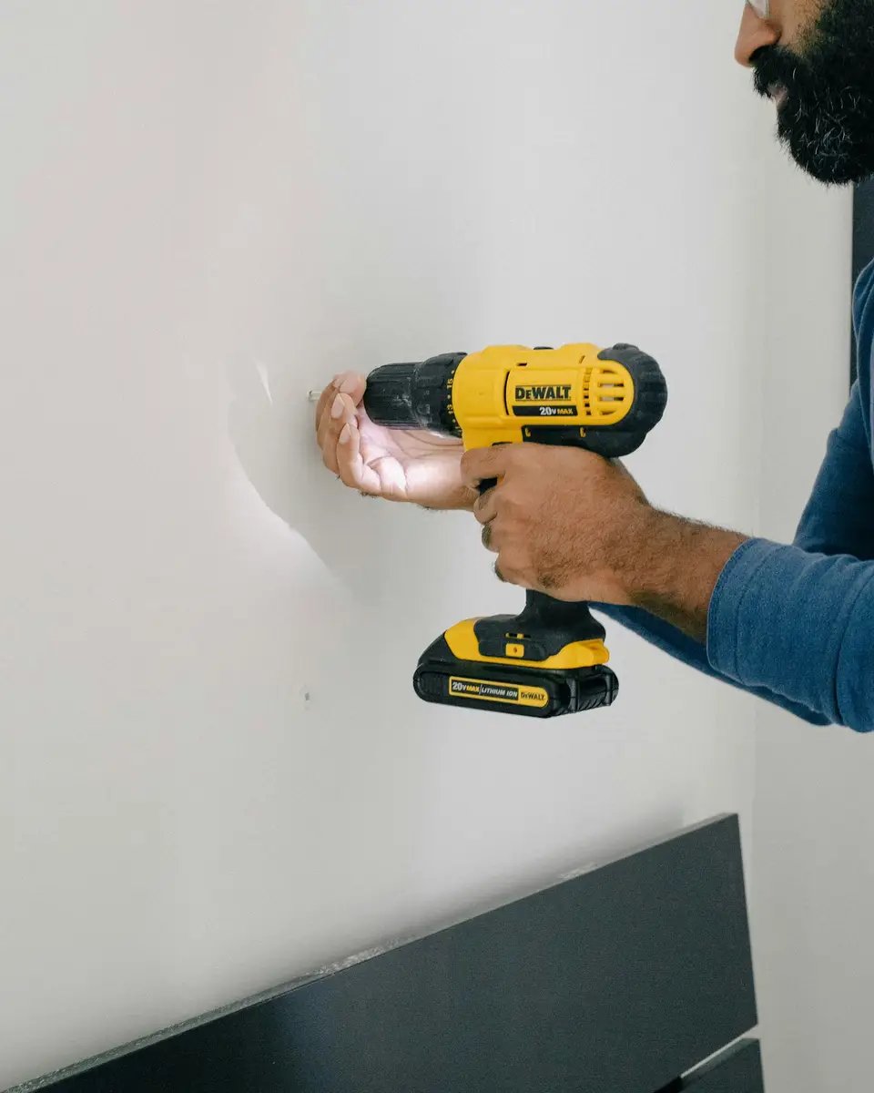 A cordless drill fixing into a plastered wall