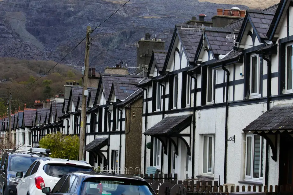 A terrace of houses below a hillside